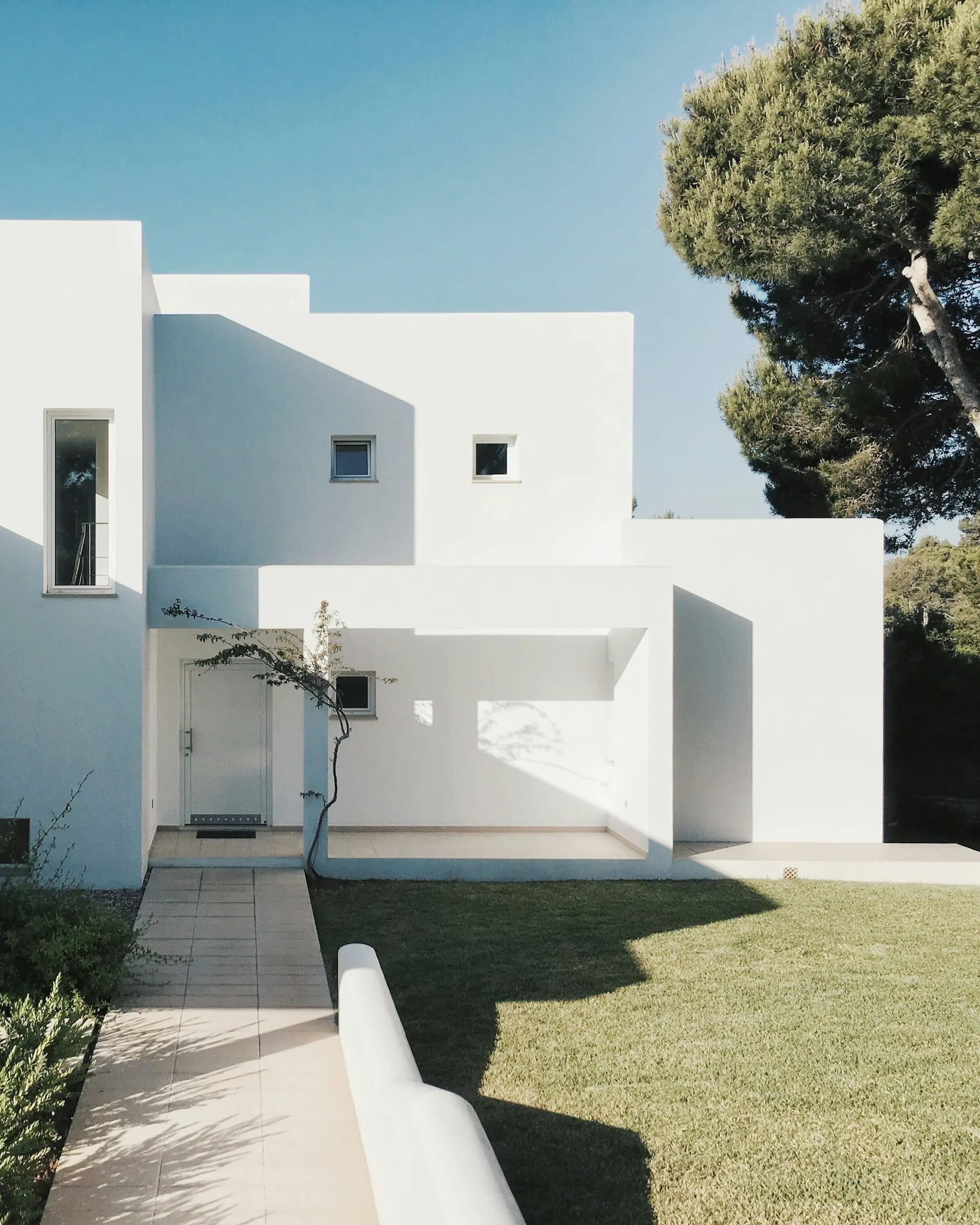 Volumes blancs et épurés de la villa se détachant sur la végétation méditerranéenne